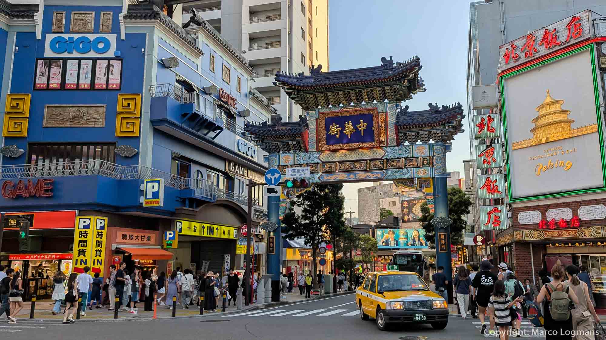 Kiosques Residentieel Chinatown in Tokyo, Japan met traditionele poort en drukke straat vol toeristen en gele taxi's.